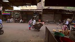 印度婦女在德里大街停放著一輛手推車。