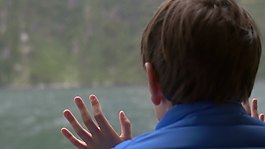 望着窗外的小男孩