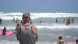 俯瞰繁忙海滩的老人