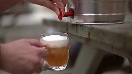在酒吧花园里从酒桶里倒啤酒
